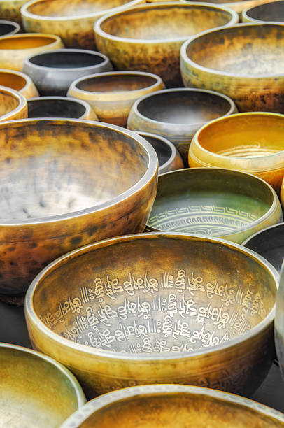 A collection of brass Tibetan singing bowls detailed with ornate Sanskrit engravings, used for meditation and mindfulness exercises