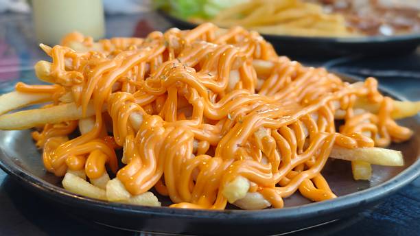 istock French fries covered in cheesy dip. 2253220591