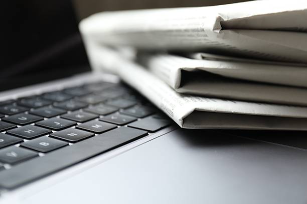 istock Stack of newspapers on laptop, closeup view 2253226982