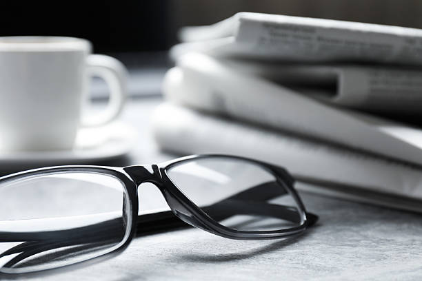 istock Newspapers, glasses and cup on grey table, closeup 2253226983