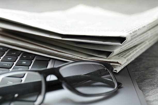 istock Newspapers, laptop and glasses on grey table, closeup 2253226984
