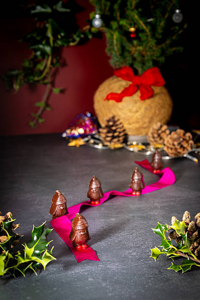 istock Chocolate penguins at Christmas on a table with Christmas decorations in the background 2253229571