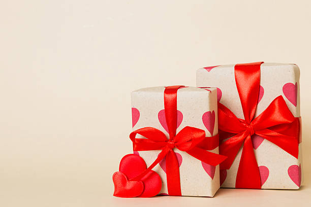istock gift box with red bow and red heart on colored background. Perspective view. Flat lay 2253230753