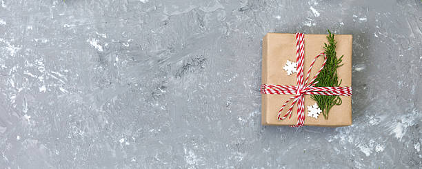 istock Christmas background with fir tree and gift box on gray cement table. Top view with copy space for your design 2253230918
