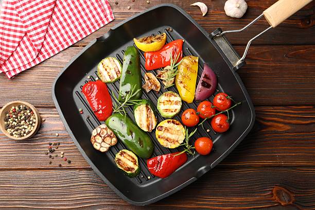 istock Pan with grilled vegetables and spices on wooden table, top view 2253231354