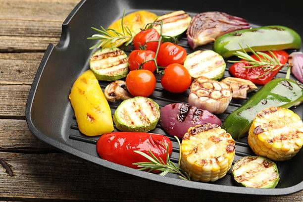 istock Pan with grilled vegetables and spices on wooden table, closeup 2253231409