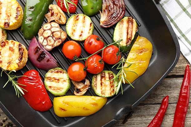istock Pan with grilled vegetables and spices on wooden table, top view 2253231429