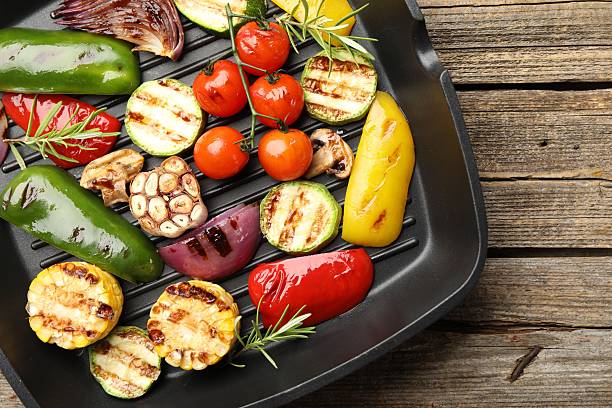 istock Pan with grilled vegetables and spices on wooden table, top view 2253231457