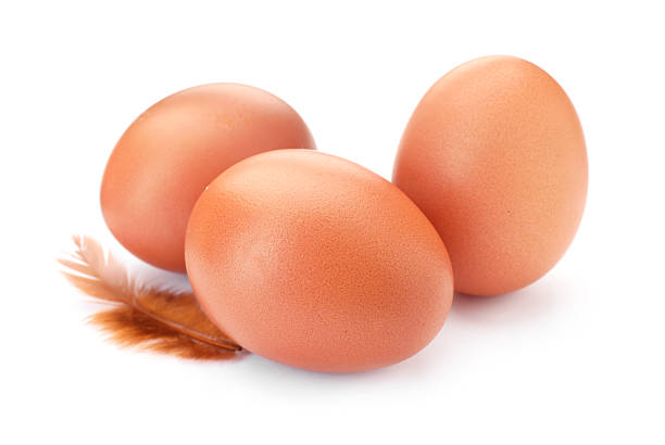 istock Raw chicken eggs and feather isolated on white 2253231666