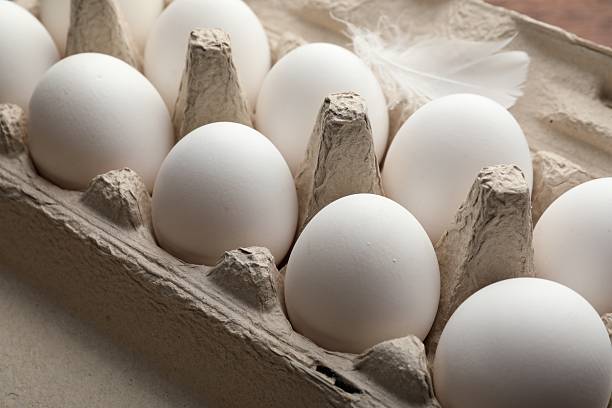 istock Raw chicken eggs in egg carton and feather, closeup 2253231691