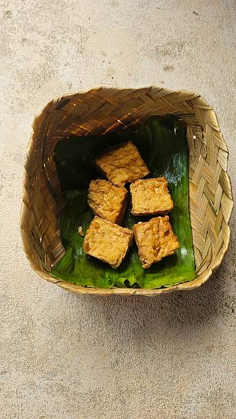 istock Warmly fried Sumedang Indonesia tofu is placed in a woven bamboo container lined with banana leaves. 2253231721