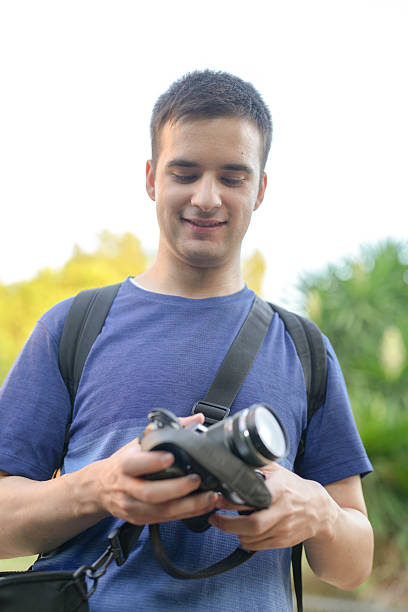 istock A man is holding a camera and smiling 2253231873