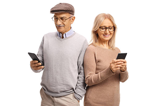 Happy mature man and woman browsing the internet on mobile devices isolated on white background