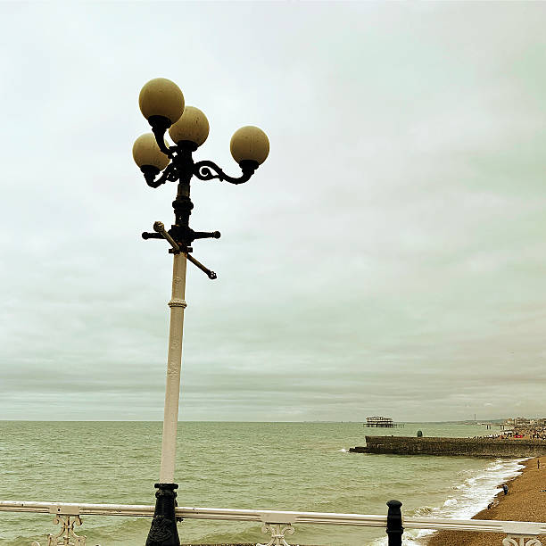 Beach boardwalk on seafront promenade at Brighton in East Sussex, England. Piew in distance. Sunshine in early Springtime.