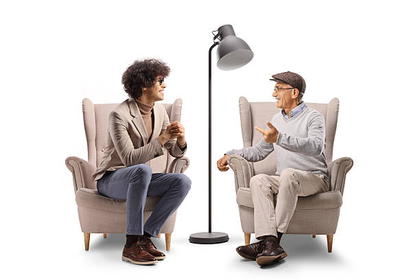 istock Young man and elderly man sitting in armchairs and having a conversation 2253236855