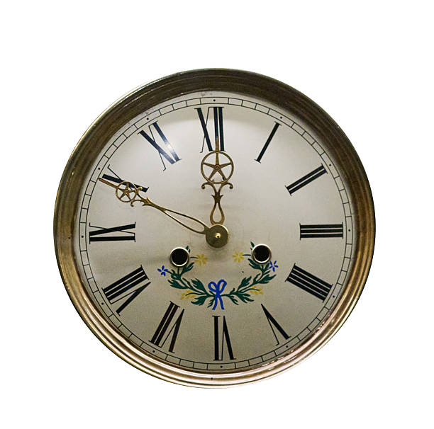 Front view of a decorative antique wall clock with Roman numerals and floral details, isolated on a white background. Vintage mechanical timepiece representing time, history, tradition, and classic interior decor.