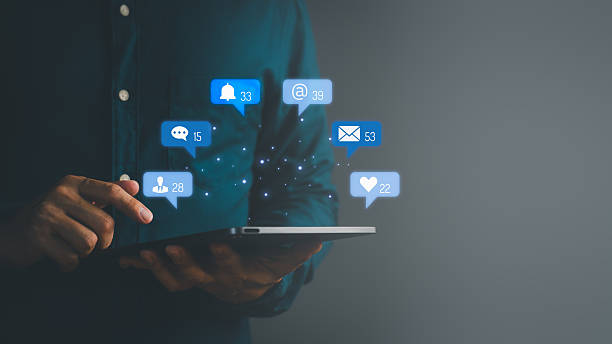 istock Man using digital tablet with floating social media notification icons, symbolizing online communication, messaging, email, followers, likes, and digital network connectivity. 2253241519
