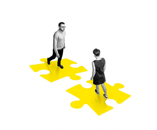 istock Two people standing on two yellow puzzle pieces 2253241697