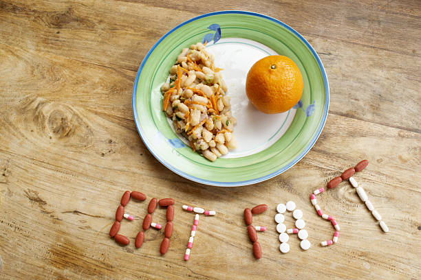 istock eat fast concept made with pills and clock on wooden background 2253243335