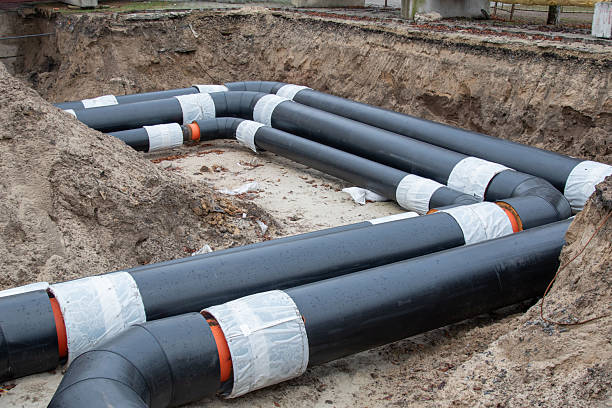 istock Insulated district heating pipes installation in deep urban trench 2253245640