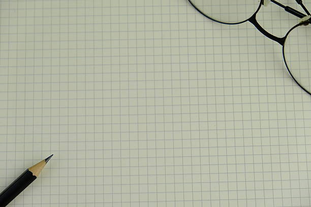 Graph paper spiral Notebook on top of brown cardboard, top view.