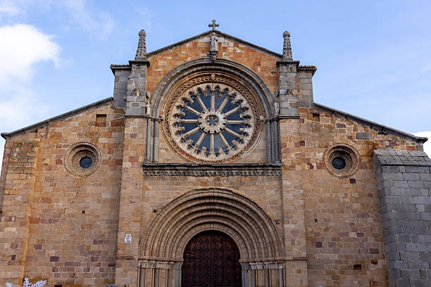 A large stone building in Avila with a large stained glass window. The building is old and has a sense of history