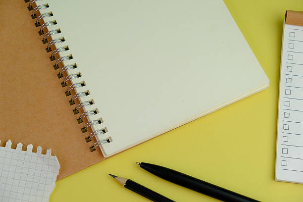 istock Open blank spiral notebook with black pencil on yellow background. Empty Space for your text. business and education concept 2253246416