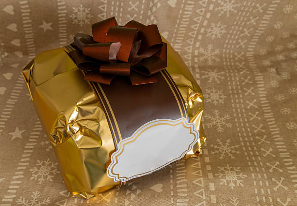 Luxury gift packaging with metallic gold foil and chocolate brown ribbon showing a blank white space for personalized messages