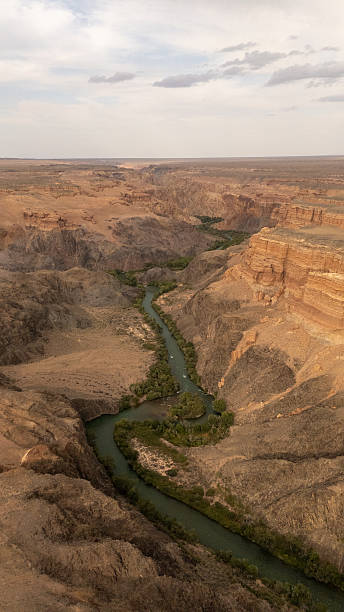 istock Winding river cuts through vast desert landscape with steep cliffs on either side 2253251536