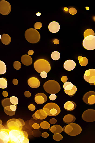 Vertical banner - holiday orange yellow bokeh on black background. New Year gold light or flying lantern festival.