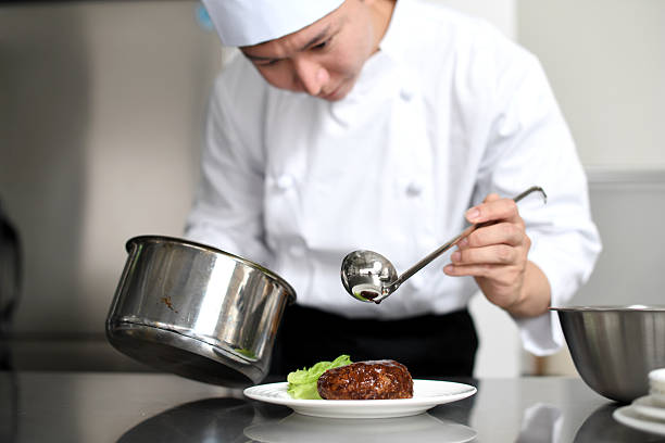 Asian chef carefully arranging food in the kitchen
