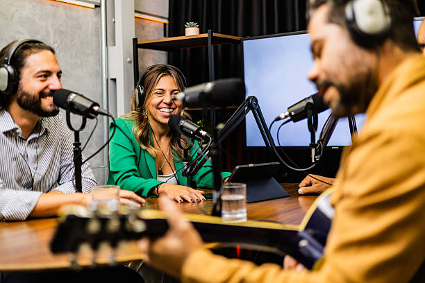 istock Podcast hosts looking singer playing a guitar on a studio 2253254230