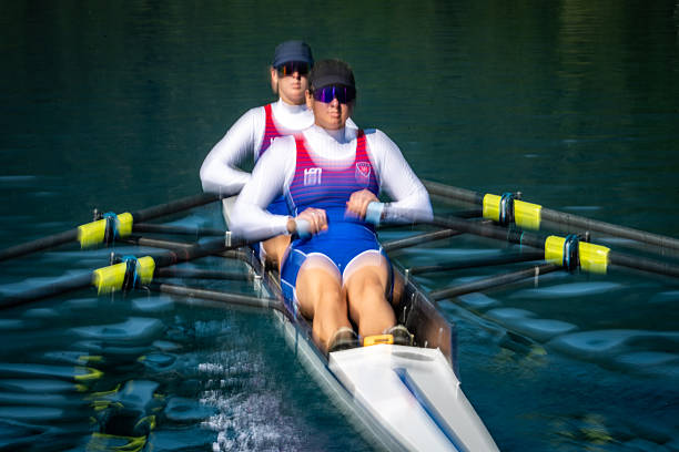istock Two Women Rowing Intensely in Double Scull on Serene Lake 2253254897
