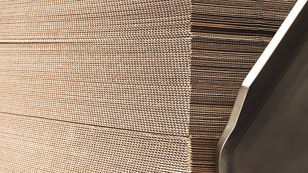 istock Elements of corton boxes are collected in stack. Conveyor line for the production of boxes. Machine cuts cardboard boxes from sheets of cardboard. Enterprise for  production package. 2253257573