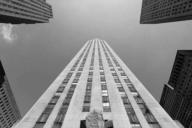 Rockefeller center’s classic skyscraper architecture with many windows and an american flag flying in new york city