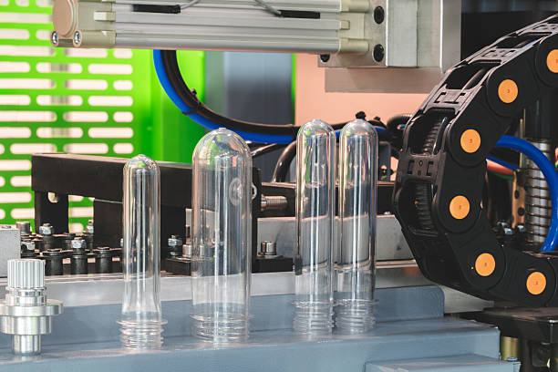 istock PETG plastic preforms for bottle making on the conveyor belt before the hot blow molding machine 2253259123
