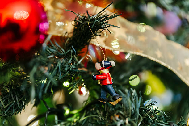 Close-up details of Christmas tree decorations featuring ornaments, lights, ribbons and festive elements. Warm holiday atmosphere with traditional Christmas symbols, ideal for seasonal backgrounds, celebrations, winter holidays and festive design concepts.
