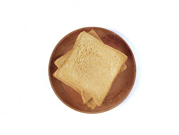 Toast bread slices on wooden plate isolated on white background. Top view