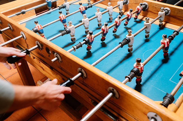 istock Close-Up of hands Playing Foosball 2253260532