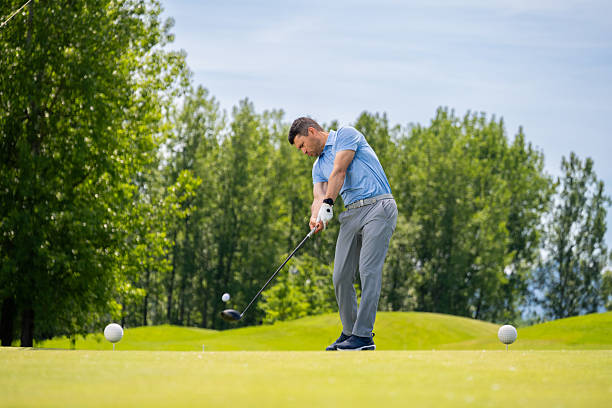 Low angle view against sky of a fit pensive senior man in sportswear standing looking to the side with a thoughtful expression with copyspace