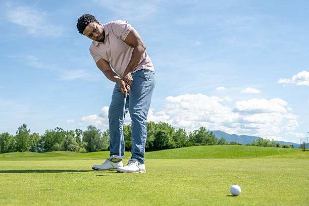 istock Young Hispanic Male Golfer Aiming Putt with Intense Focus 2253260877