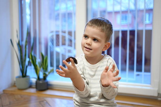 Child with a cockroach in hand, concept of biology education and hands-on learning.