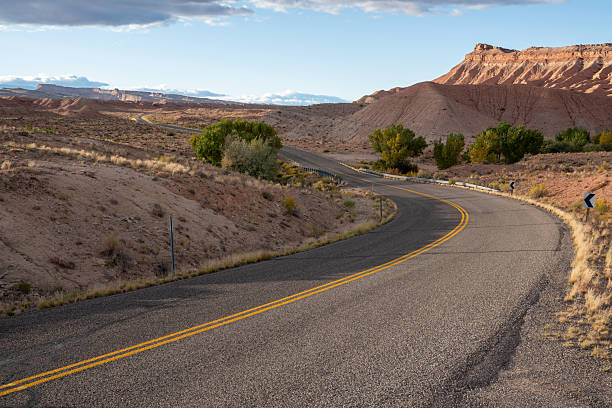A road with a yellow line down the middle. The road is empty and there are no cars on it