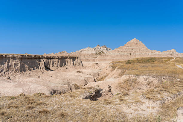 Large hill with a small hill on top. The hill is barren and rocky. The sky is blue and clear