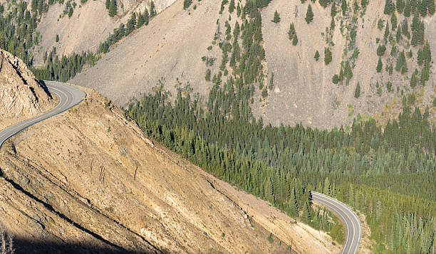 istock Mountain road with trees on the side 2253265238