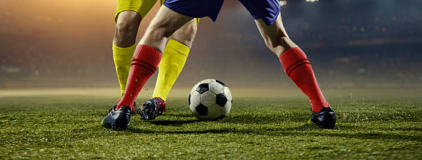 istock Dynamic football leg battle with rapid direction change under stadium lights. 2253268305