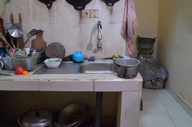 istock Various Metal Pots And Kitchen Utensils Placed Around A Stainless Steel Sink 2253272289