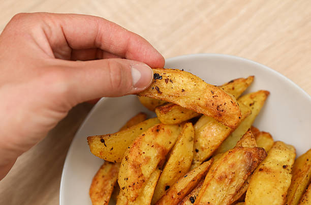 istock Hand holding Fried potatoes peasant style on a plate 2253273430