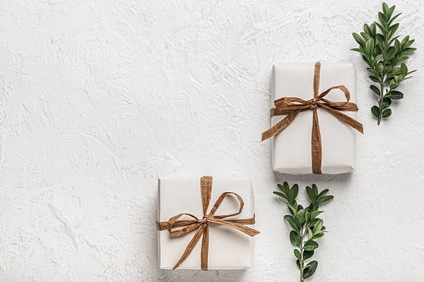 istock Two gift boxes on a white background and green boxwood branches. Handmade gifts concept. Postcard, mock-up. 2253274742