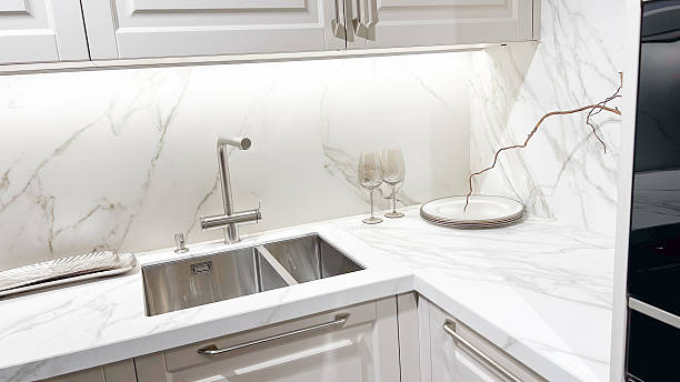istock Luxurious modern kitchen, white marble counter, clean steel sink, elegant cabinets, ambient lighting, decor. 2253276965